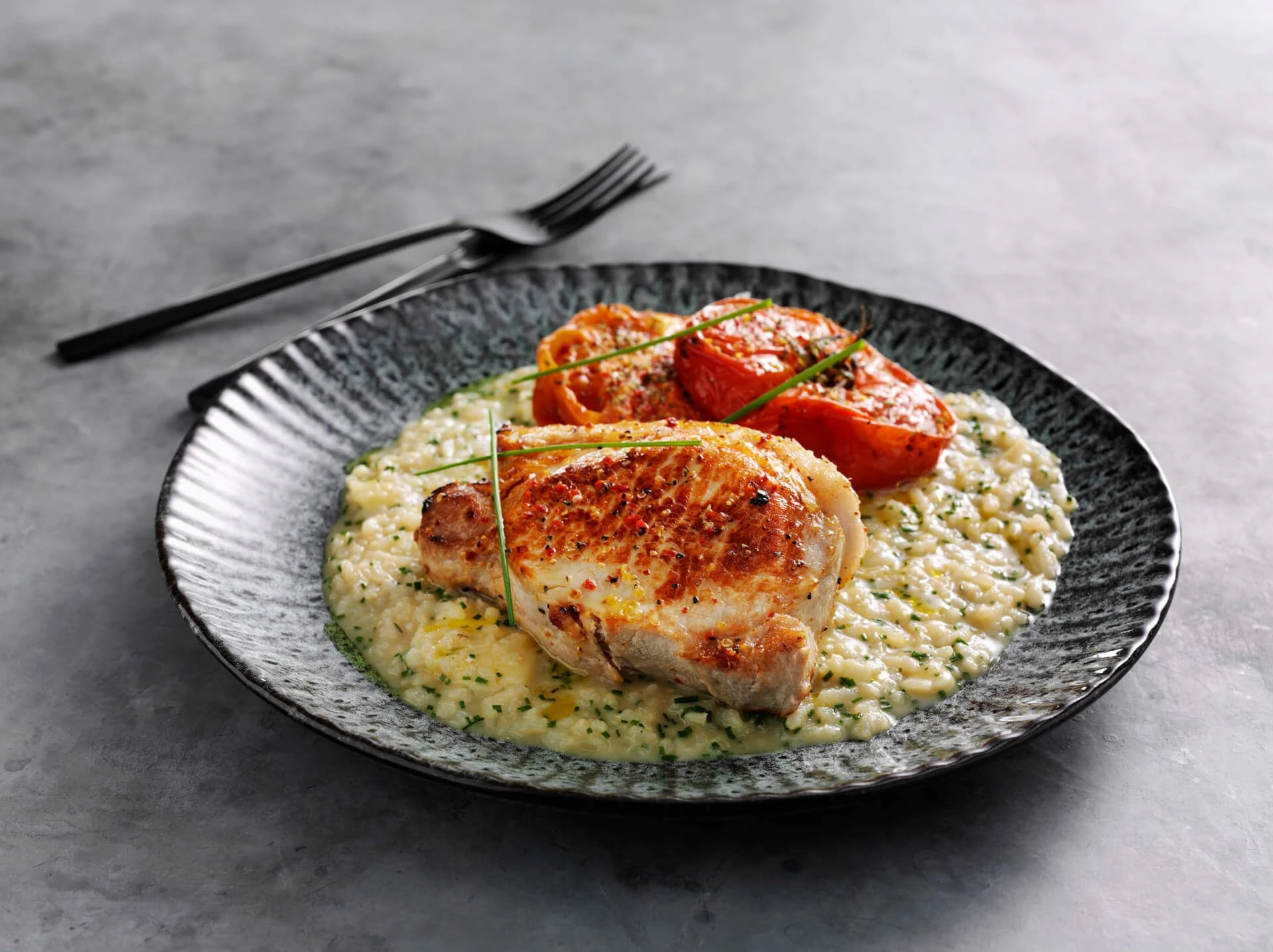 Stegte koteletter med risotto og bagte tomater