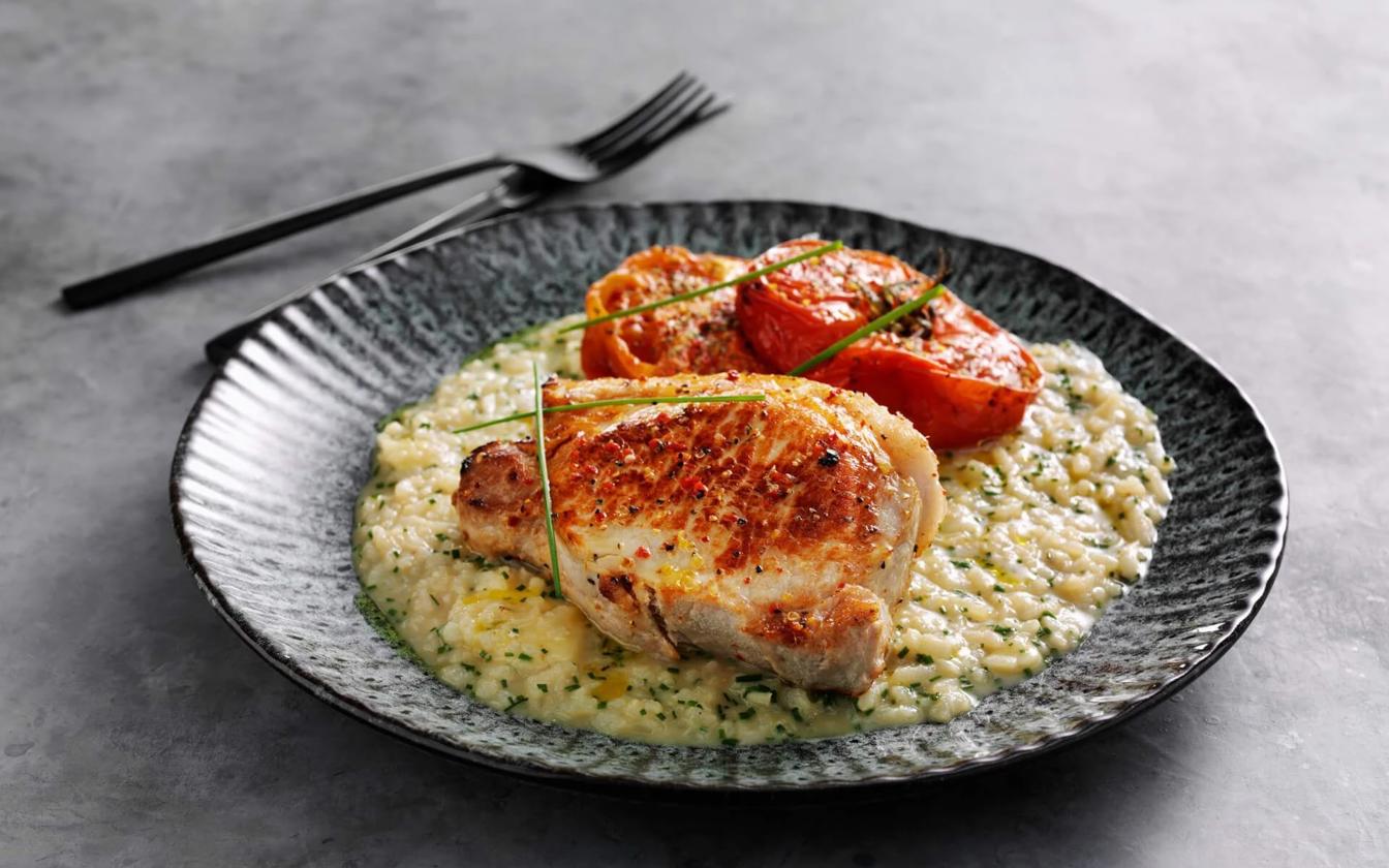 Stegte koteletter med risotto og bagte tomater